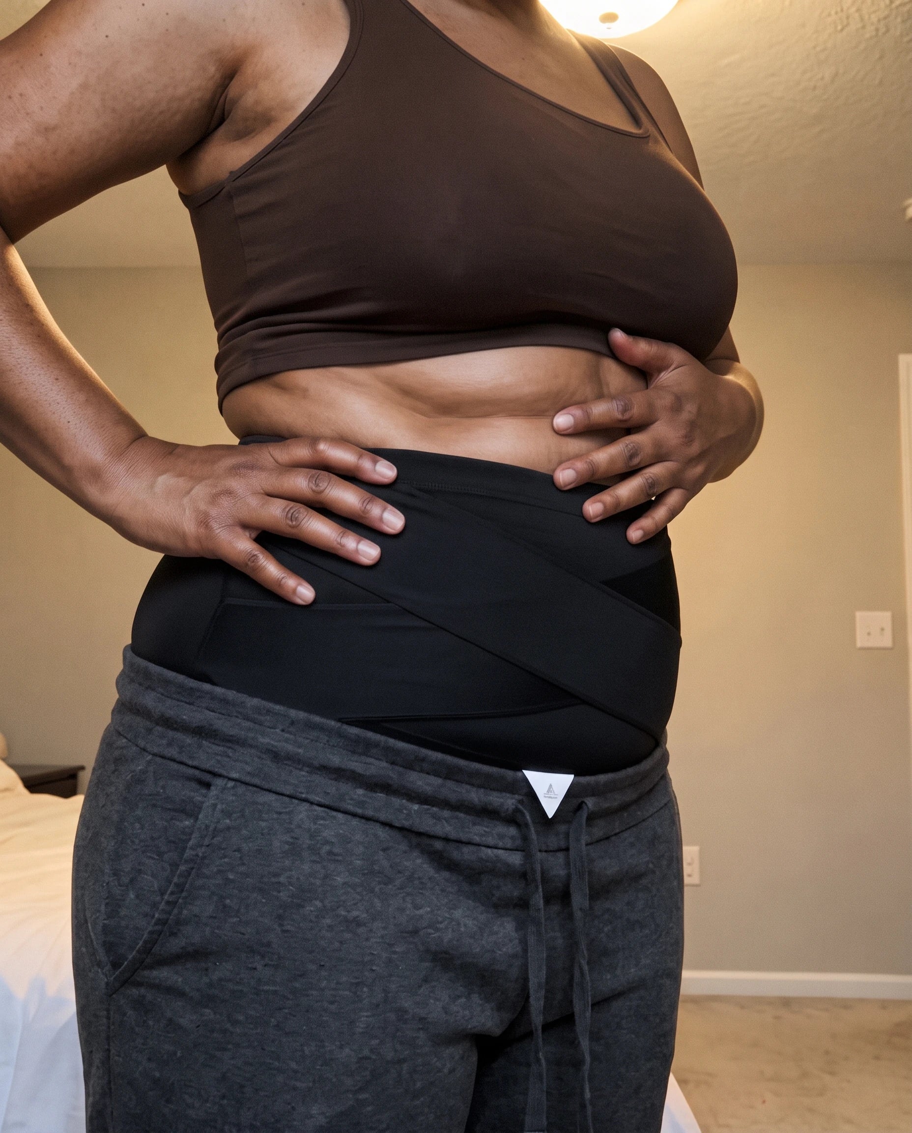 Woman standing with hands on her hips wearing the black Snoothe support brief
